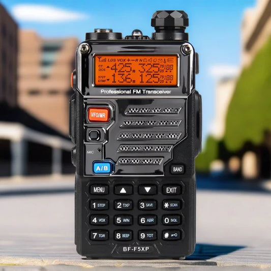 Black dual-band two-way radio with an orange backlit display and a full keypad.