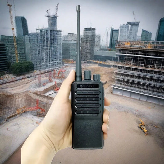 Black handheld walkie-talkie with an antenna and multiple control knobs.
