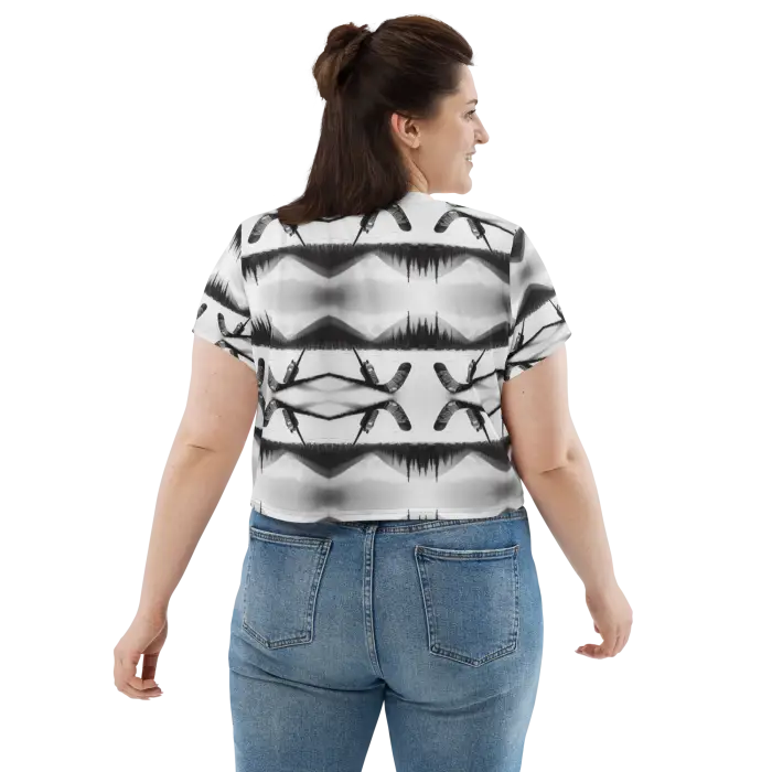 Woman wearing patterned crop top and jeans.