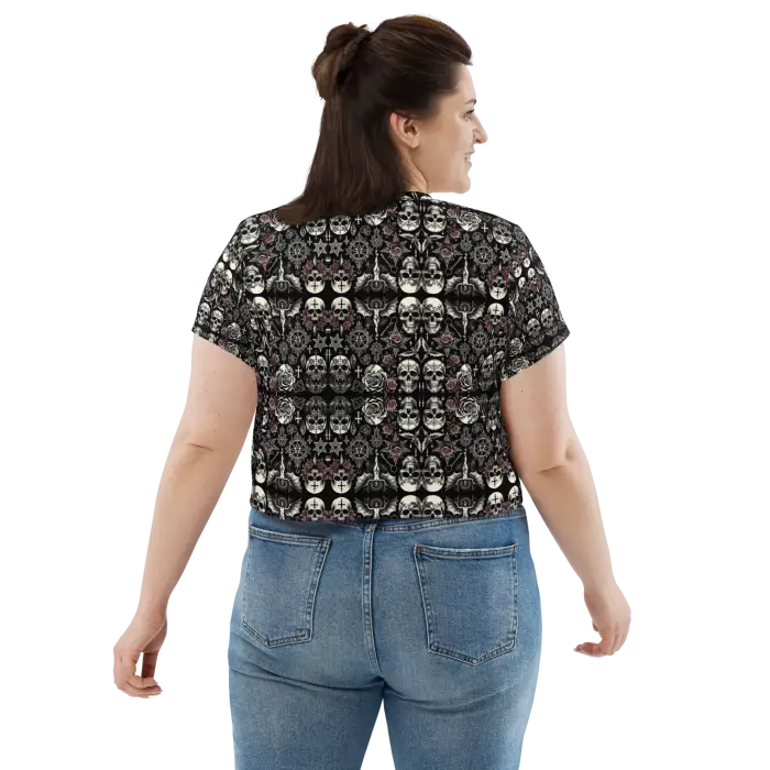 Woman wearing skull-patterned crop top and jeans.