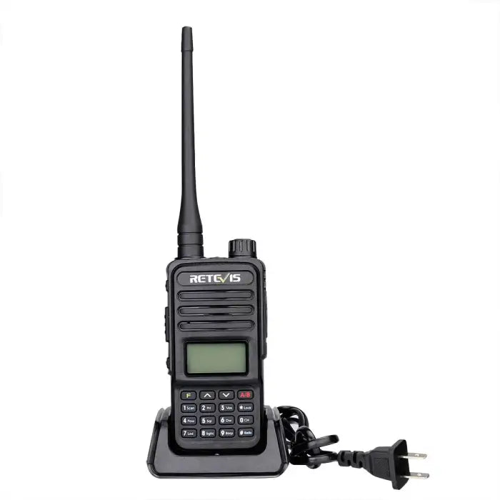 Handheld two-way radio with antenna, display screen, keypad, and charging base.