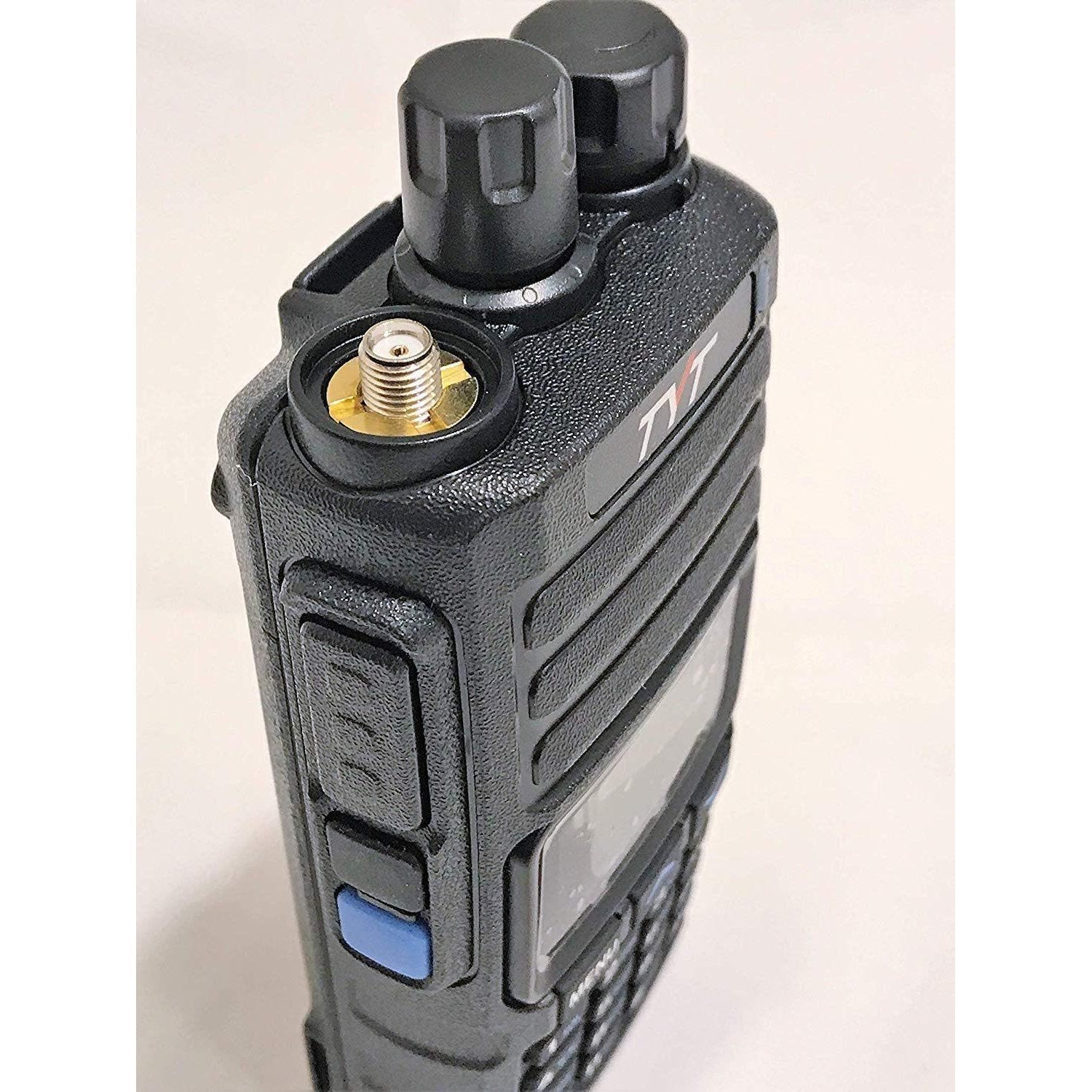 Black two-way radio with visible antenna connector, volume/channel knobs, and side buttons.