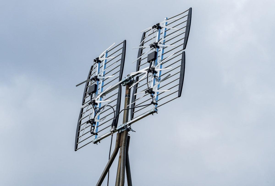 a television antenna on a pole with a sky background