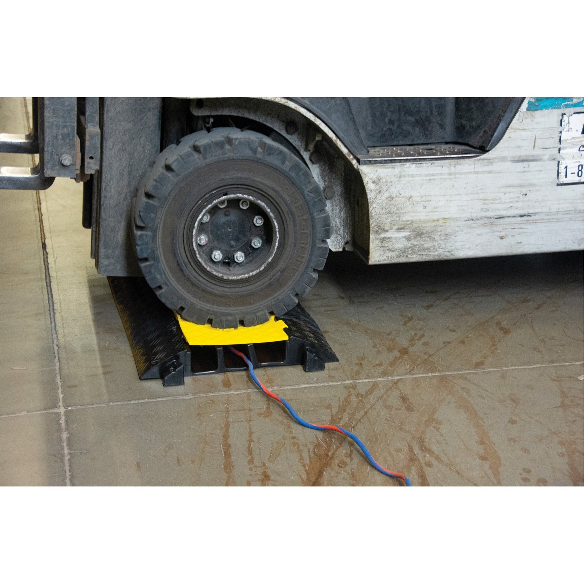 A heavy-duty cable protector with a yellow cover, designed to shield cables from vehicle traffic.