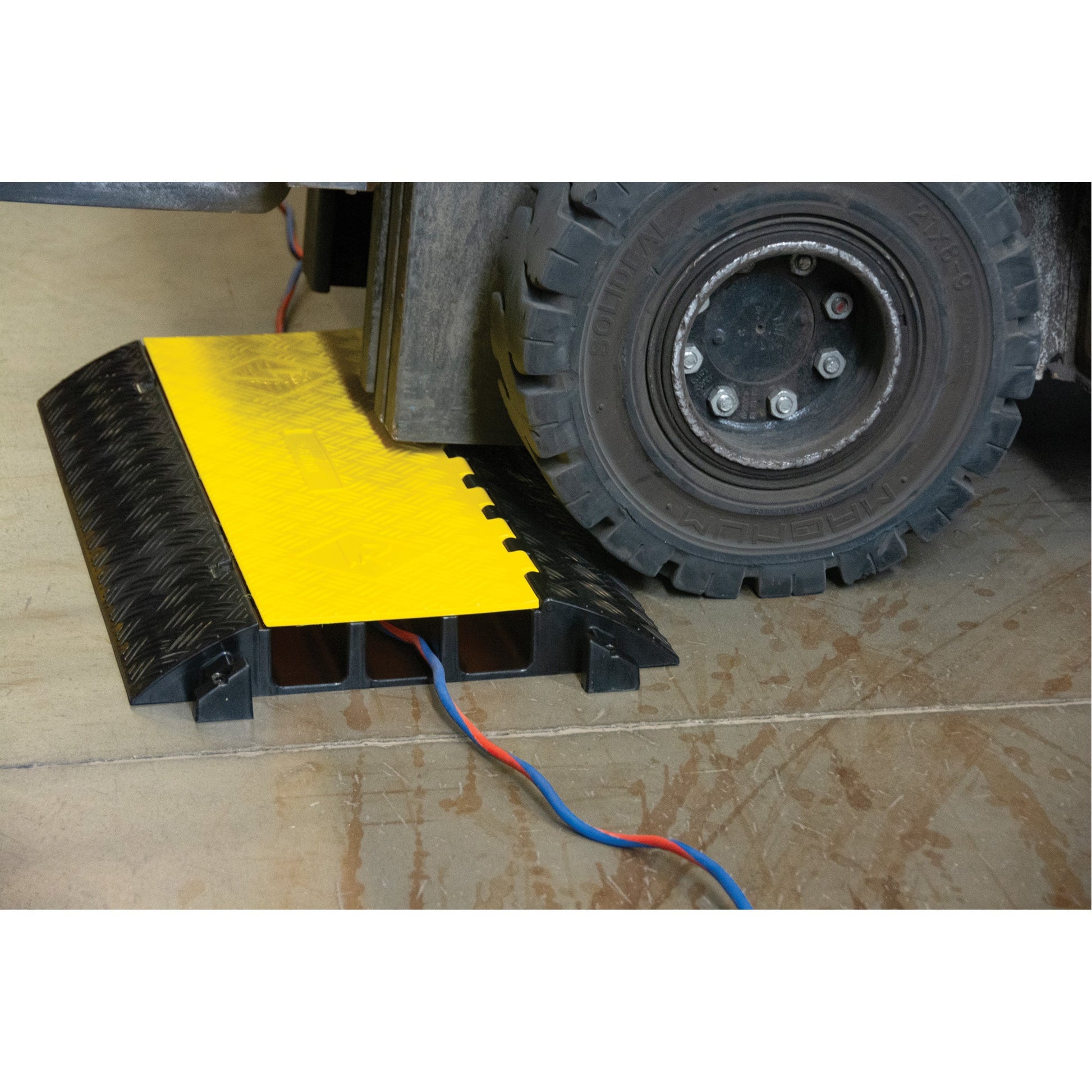 Heavy-duty yellow and black cable protector ramp with two channels for wires.