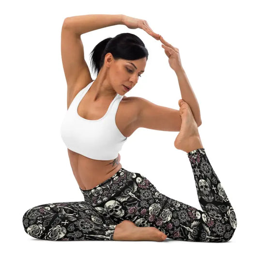 Woman in yoga pose wearing skull-patterned leggings.