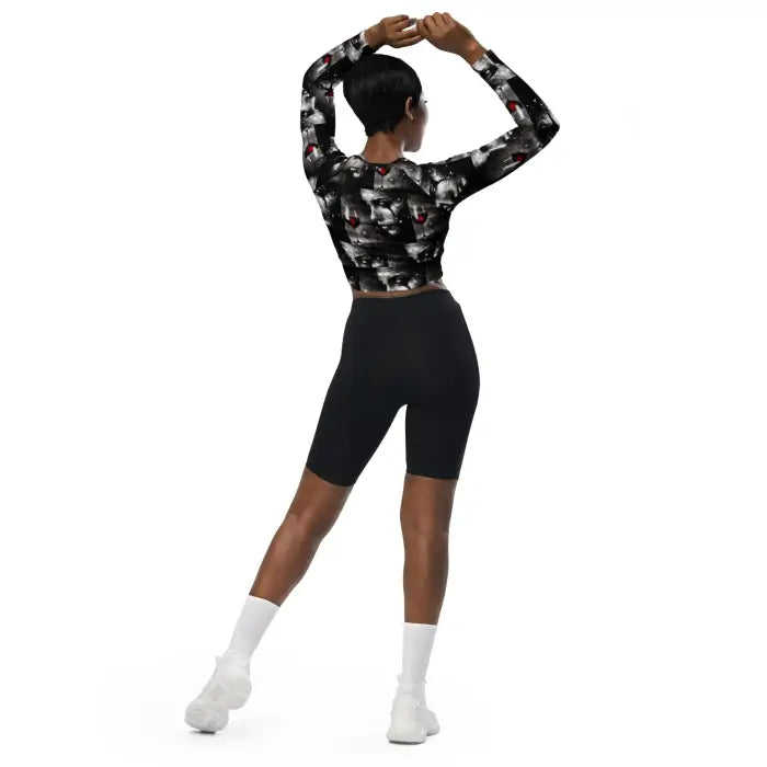 Woman wearing patterned crop top and black shorts.