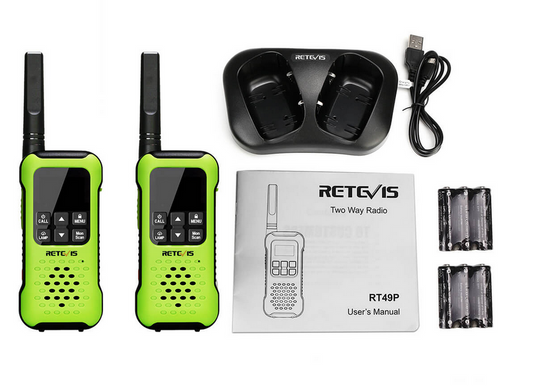 Two green walkie-talkies with charging station, batteries, and user manual.