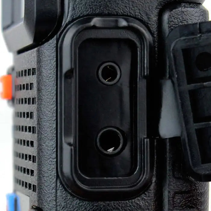 Close-up view of a camera or electronic device port with two small circular openings.