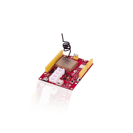 A red circuit board with multiple white connectors, yellow pin headers, and a coiled wire antenna.