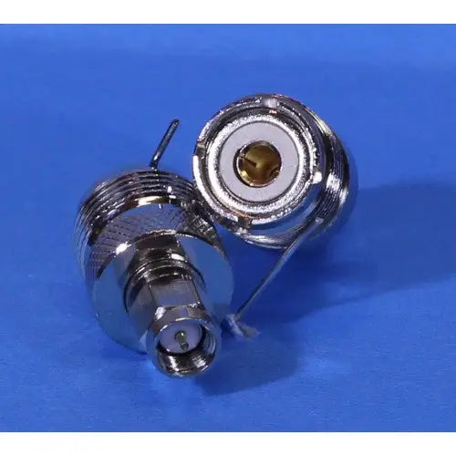 Metallic coaxial cable connector with threaded components and a central pin.