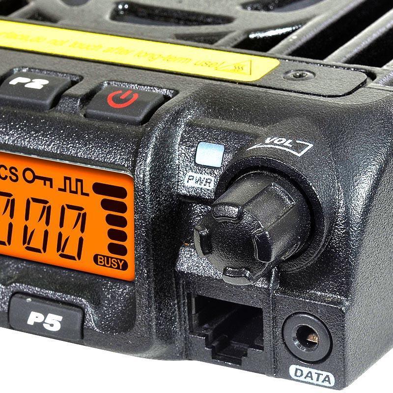 A black two-way radio with an orange digital display and various control buttons and knobs.