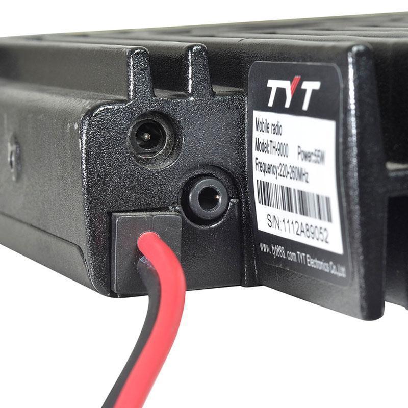 Rear view of a black mobile radio with power and audio jacks.
